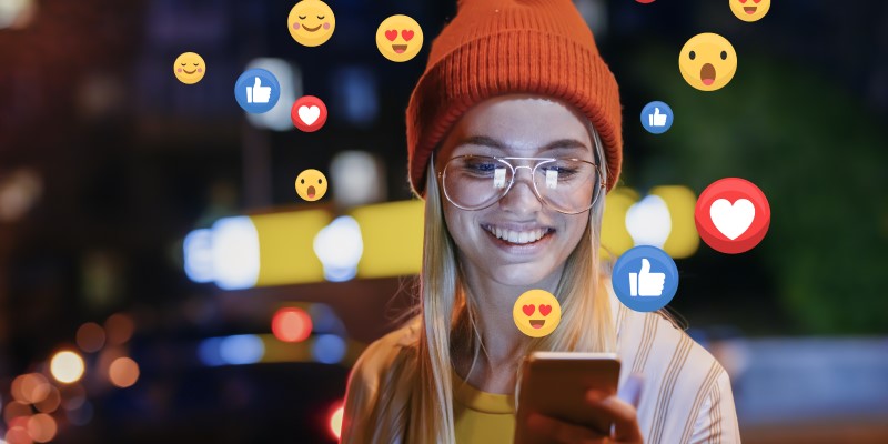 Lachende Frau nutzt Social Media auf Smartphone